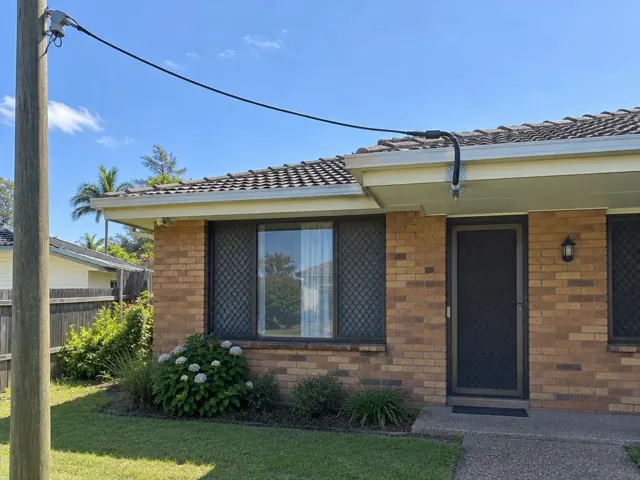 Brick house exterior with overhead service cable and bracket under the eave in Bateau Bay